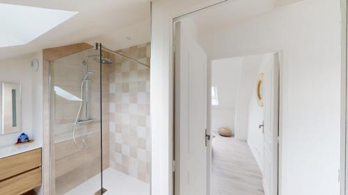 une salle de bain avec douche et porte vitrée dans l'établissement Appartement Les Sables d’Or, à Barneville-Carteret