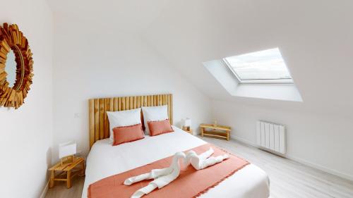 une chambre avec un lit avec deux serviettes dessus dans l'établissement Appartement Les Sables d’Or, à Barneville-Carteret