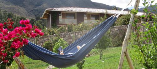 a person sleeping in a hammock in a yard at Casa de Oren in Pisac