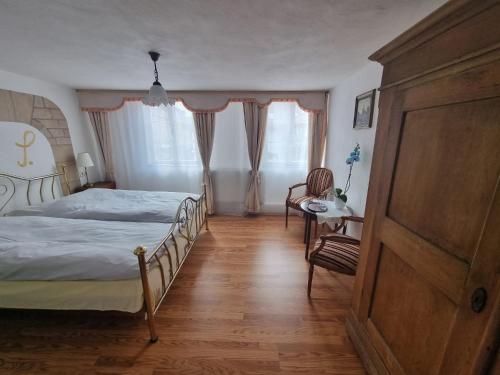Schlafzimmer mit einem Bett, einem Tisch und Stühlen in der Unterkunft Gasthof zum Stern in Bad Brückenau
