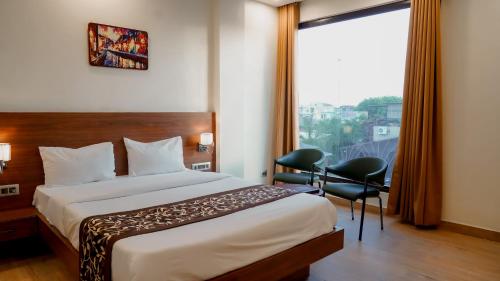 1 dormitorio con cama, escritorio y ventana en Hotel Chulhewala en Jhānsi