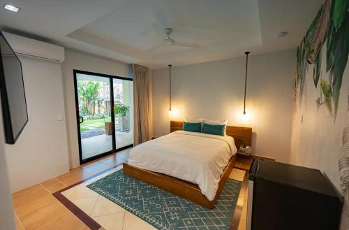 a bedroom with a bed and a tv in it at Marala Hotel in Esterillos