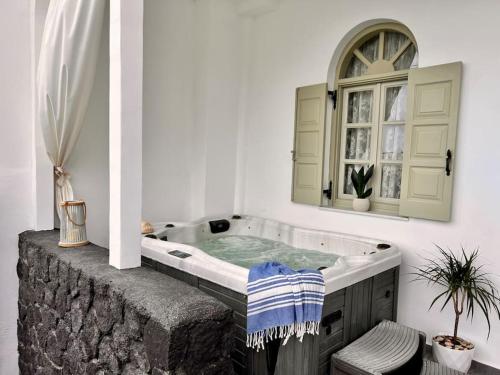 a bath tub in a room with a mirror at Luxury Vacation Villa Irene with private juccuzi in Fira