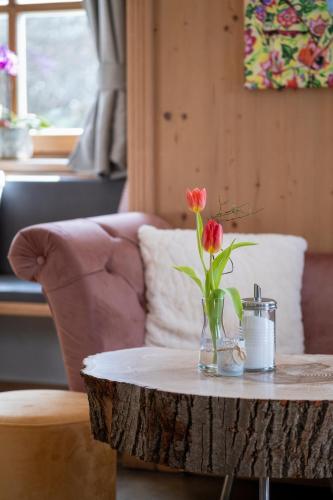 a vase of flowers on a table in a living room at Servus Gelting in Geretsried
