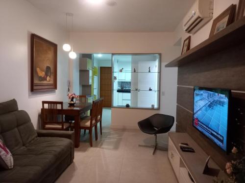 ein Wohnzimmer mit einem Sofa, einem TV und einem Tisch in der Unterkunft FLATS Atlantico Praia in Rio de Janeiro