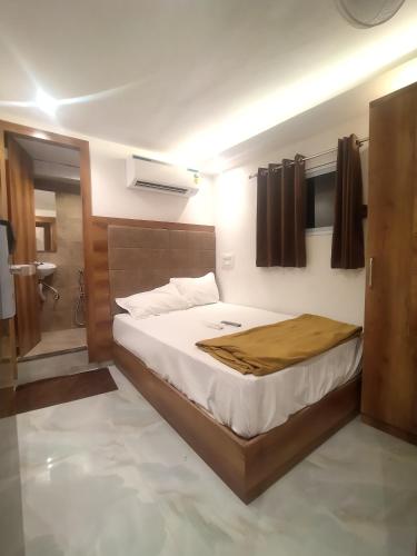 a bedroom with a large bed and a bathroom at Hotel Kishan Lodging & Boarding in Mumbai