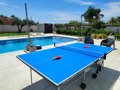 a ping pong table in front of a swimming pool at Suite12 in Marsala