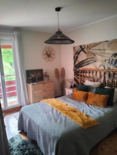 - une chambre avec un grand lit et une lampe pendant dans l'établissement Maison au calme wifi Netflix, à Hendaye