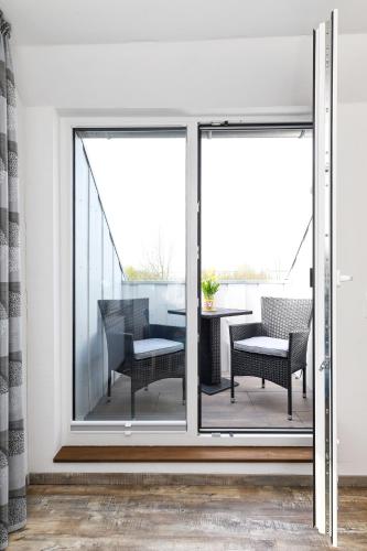 a balcony with sliding glass doors with a table and chairs at Haus zur Möwe mit Frühstücksoption in Bensersiel