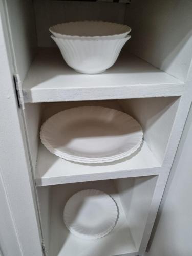 a white shelf with plates and a bowl on it at Departamento en pleno centro Don Bosco 73 in Mendoza