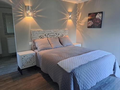 sypialnia z łóżkiem i 2 lampkami na ścianie w obiekcie VILLA PALMIER avec PISCINE CHAUFFÉE PRIVÉE proche D'UZES ET ANDUZE w mieście Cannes-et-Clairan