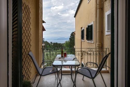 un patio con tavolo e sedie sul balcone. di Roxandra Suite Corfu a Evropoúloi