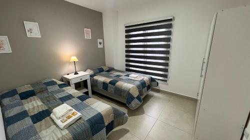 una habitación con dos camas y una ventana en Depto Magallanes, en Ushuaia