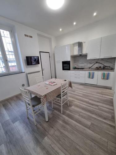 a dining room with a table and chairs and a kitchen at Appartamento viktor in Cislago