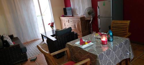 uma cozinha com uma mesa e cadeiras e um frigorífico em Le Chaleureux em La Gaulette