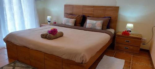 a bedroom with a large bed with two towels on it at Le Chaleureux in La Gaulette