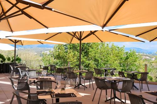 a patio with tables and chairs with umbrellas at Thalazur Antibes - Hôtel & Spa in Antibes