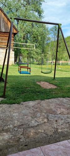 a park with a swing set in the grass at A&M studio apartman in Otočac