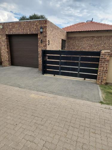 un garage avec une porte de garage et un bâtiment en briques dans l'établissement @Lloyds, à Ermelo