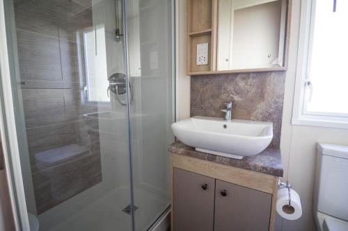 a bathroom with a sink and a shower at Beautiful Lodge At Manor Park In Hunstanton Ref 23018k in Hunstanton