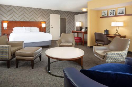 a hotel room with a bed and chairs at Courtyard by Marriott Fishermans Wharf in San Francisco