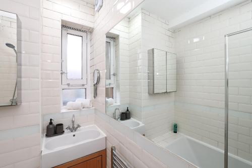 倫敦的住宿－3BDR Kings X Apt for 7 with Balcony and near tube，白色的浴室设有水槽、浴缸和淋浴。