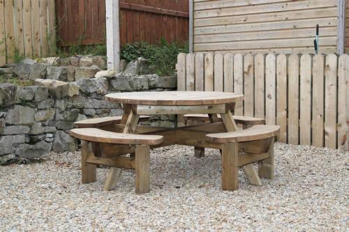 a picnic table and two benches in front of a fence at 4 Castle Court in Enniskillen