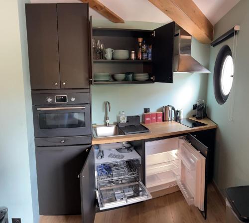 a small kitchen with black cabinets and a sink at Le petit clocher de Cassis in Cassis