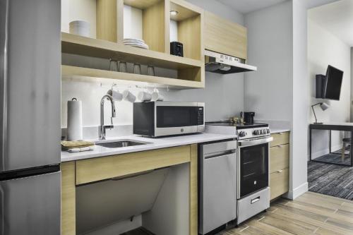 a kitchen with a sink and a microwave at TownePlace Suites by Marriott San Antonio Universal City, Live Oak in Selma