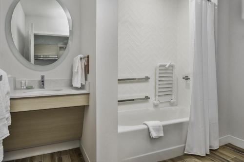 a bathroom with a tub and a sink and a mirror at TownePlace Suites by Marriott San Antonio Universal City, Live Oak in Selma