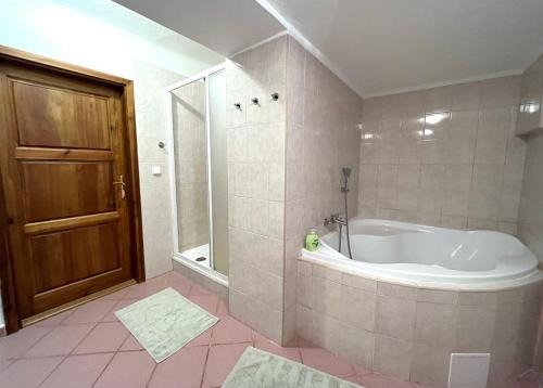 y baño con bañera y ducha a ras de suelo. en Apartmány Na Rynku Chvalšiny 18, en Český Krumlov
