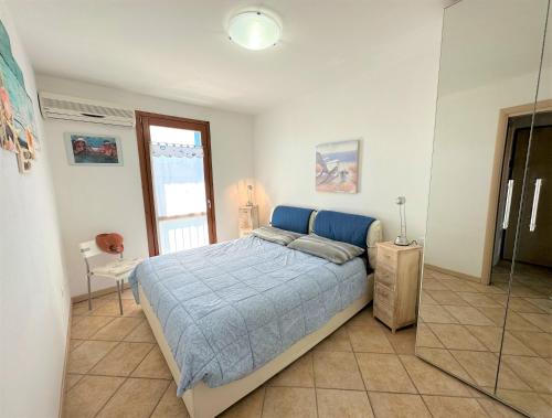 una camera con letto e piumone blu di Porto Antico Village ad Aprilia Marittima