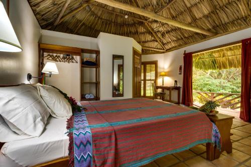 een slaapkamer met een groot bed in een kamer bij Tanager RainForest Lodge in Big Falls