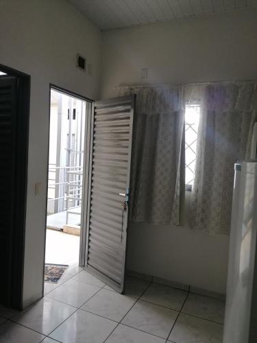 um quarto vazio com uma porta e uma janela em Quarto para Rapazes no Centro Sinop MT em Sinop