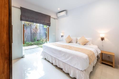 een slaapkamer met een groot wit bed en een raam bij Villa Bella in Sanur