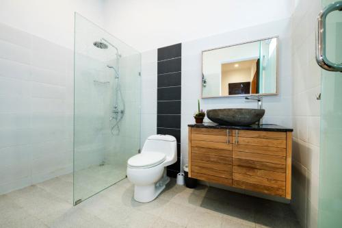 een badkamer met een toilet, een wastafel en een douche bij Villa Bella in Sanur
