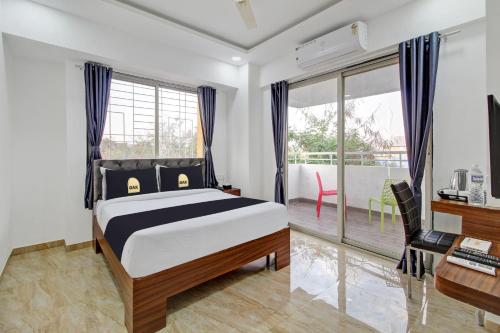 um quarto com uma cama, uma secretária e uma janela em Townhouse OAK Red Velvet Suites & Inn Koregoan Park em Pune