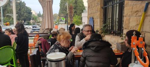 Un groupe de personnes assises à une table et mangeant de la nourriture dans l'établissement Rothschild Mansion, à Haïfa