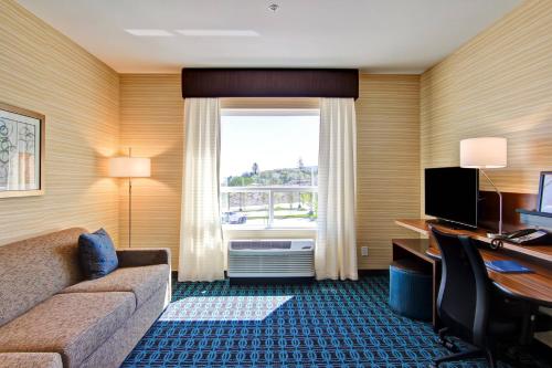 a hotel room with a couch and a window at Fairfield Inn & Suites by Marriott Kamloops in Kamloops