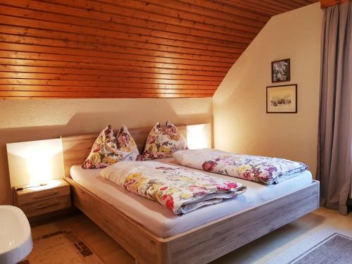a bedroom with two beds and a wooden ceiling at Bergbauernhof Rebernig in Lendorf