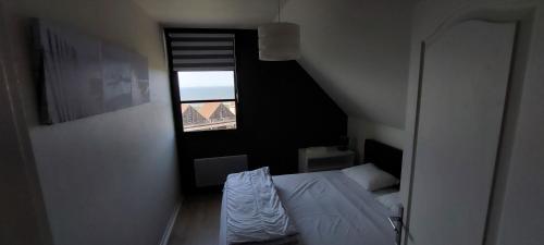 Habitación pequeña con cama y ventana en Le 246 - Duplex face à la mer pour 4 personnes, Wifi, TV full Sat, Parking, en Wimereux