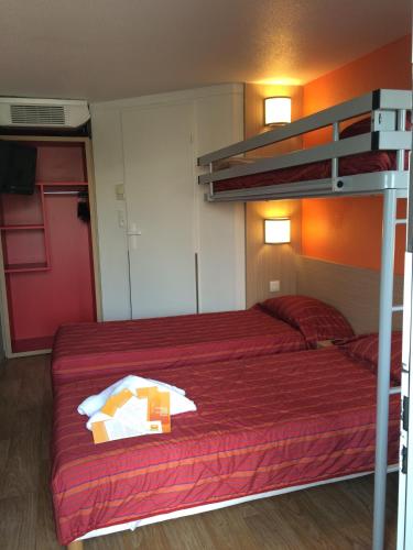 una camera con letto a castello e copriletto rosso di Premiere Classe Marseille La Valentine a Marsiglia