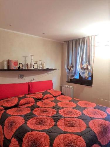 a bedroom with a red and black bed with a window at Valtournenche EVETTE in Valtournenche