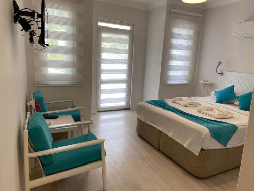 1 dormitorio con 1 cama, 1 silla y ventanas en Göcek Selya Hotel, en Göcek