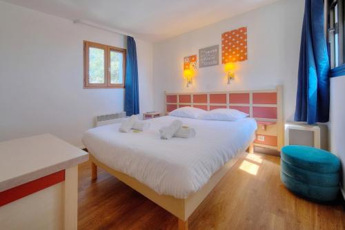 une chambre avec un grand lit et une chaise bleue dans l'établissement IMMOGROOM - sea view - Pool - Terrace - Parking - Wifi - AC, à Cannes