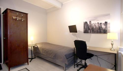 - une chambre avec un lit, un bureau et une chaise dans l'établissement Toimistohotelli Alfred Kokkola, à Kokkola