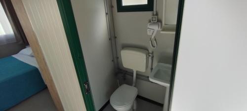 mała łazienka z toaletą i łóżkiem w samolocie w obiekcie Tropical Bungalow w mieście Diamante