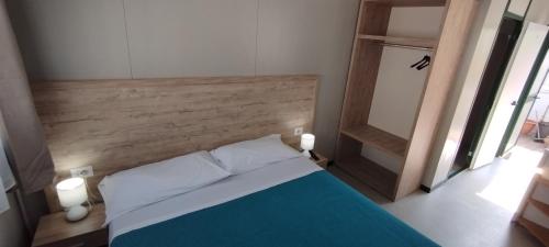 een slaapkamer met een bed met een houten hoofdeinde bij Tropical Bungalow in Diamante