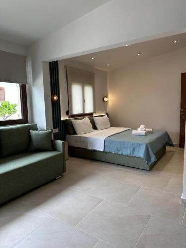 a bedroom with a bed and a couch in a room at Zinozis Beach Apartments in Vourvourou