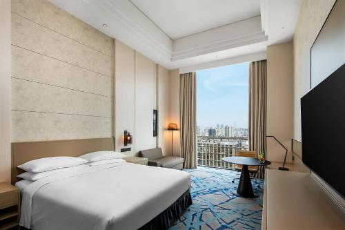 pokój hotelowy z łóżkiem i dużym oknem w obiekcie Renaissance Shanghai Caohejing Hotel w Szanghaju